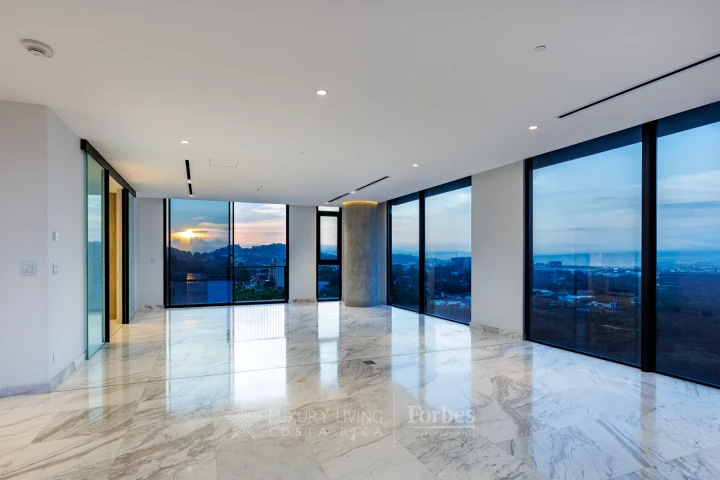 A bright modern interior with expansive windows overlooking Costa Rica.